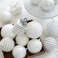 a box filled with white christmas ornaments on top of a table next to other decorations