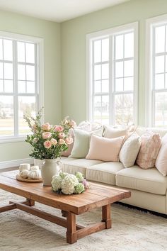 a living room filled with lots of furniture and flowers on top of a coffee table