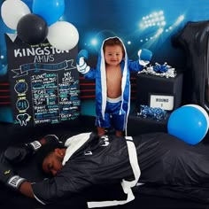 a little boy is laying on the bed in his boxing outfit