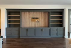 an empty living room with built in cabinets