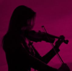 a woman holding a violin in front of a purple background