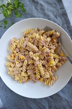 tuna pasta salad on a white plate with a fork