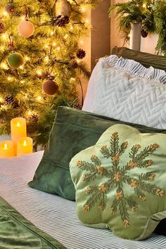 Green pillow on a bed. Anthropologie Diy Christmas, Beds Cozy, Anthropologie Design, Anthropologie Diy, Cozy Christmas Bedroom, Cozy Christmas Decor, Outdoor Chandelier, Brush Trees