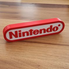 a red nintendo logo on a wooden table