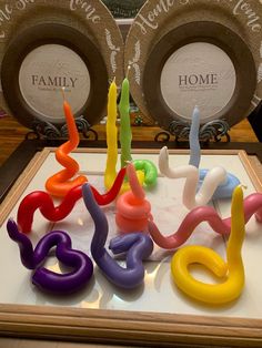 there are many candles in the shape of snake's legs on this display table