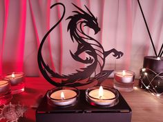 some candles are sitting on a table next to a paper cut out of a dragon