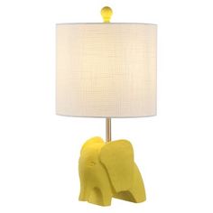 a yellow elephant lamp with a white shade on it's head and trunk resting against the base