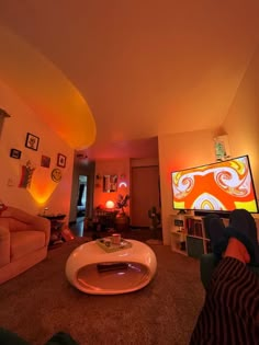 a living room filled with furniture and a flat screen tv on top of a wall