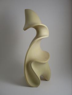 a white sculpture sitting on top of a table next to a gray wall and floor