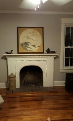 a living room with a fire place and a painting on the wall