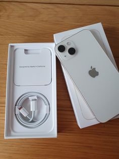 an apple iphone is in its box with the charger plugged into it's side