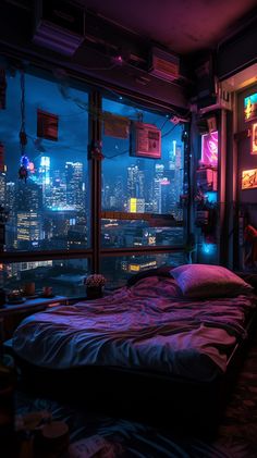 a bed sitting in front of a window next to a night time cityscape