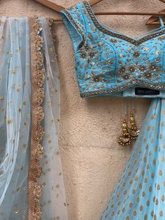 A three-piece powder blue sharmily zari lehenga set from the Priti Sahni collection. This georgette powder blue butti lehenga with pearl-zari work border detail is paired with a powder blue blouse in raw silk fabric with sequin and zardozi hand embroidery. This outfit is completed with a powder blue tulle dupatta in net material with sequin work. Festive Blue Wedding Pre-draped Saree, Light Blue Semi-stitched Lehenga With Resham Embroidery, Light Blue Resham Embroidery Sets For Navratri, Designer Anarkali In Light Blue, Traditional Light Blue Palazzo Set With Dupatta, Blue Palazzo Set With Dori Work For Party, Blue Palazzo Saree Set For Wedding, Blue Palazzo Set With Dupatta For Wedding, Bollywood Style Light Blue Sharara