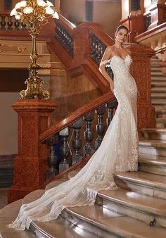 a woman in a wedding dress standing on some stairs