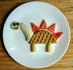 a plate with waffles, watermelon and banana shaped like a cartoon character