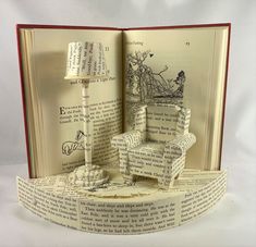 an open book with a chair and lamp inside