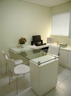 an office desk with chairs and a laptop computer on it in front of a window