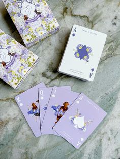 four playing cards are sitting on a marble surface