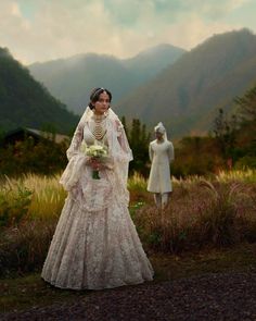 a woman in a wedding dress standing next to two mannequins