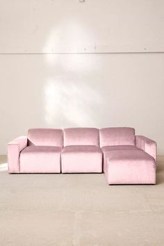 a pink couch sitting on top of a white floor