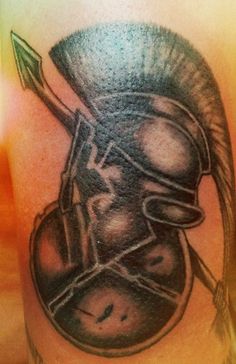 a close up of a person's arm with a helmet and arrow on it