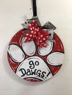 a red and white dog paw with polka dot bow hanging from a hook on a wall