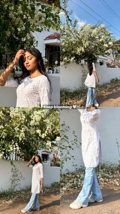 a woman in white shirt and jeans standing next to a wall with flowers on it