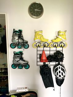 there is a clock on the wall next to some skates and snowboards in this room