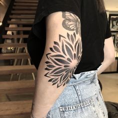 a woman's arm with a tattoo on it that has a large flower design