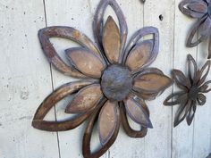 three metal flowers on a white wooden wall