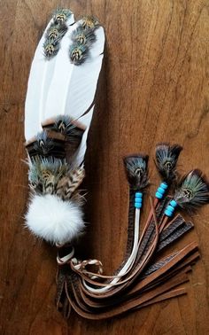 feathers and beads are arranged on a wooden table