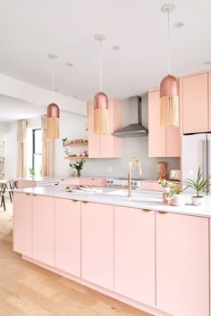 a kitchen with pink cabinets and white counter tops