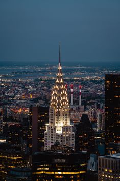 the empire building is lit up at night in new york city, with lights on it