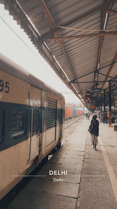 a train parked at a train station with people walking on the platform