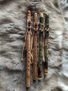 three wooden flutes sitting on top of a fur covered floor