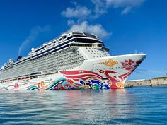 a large cruise ship in the water with its colorful paint on it's side