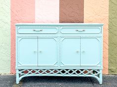 a blue cabinet sitting in front of a multi colored wall on the side of a building