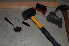 various tools are laying on the floor next to each other, including hammers and toothbrushes