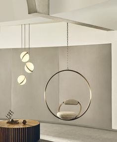 a circular chair hanging from the ceiling next to a round table