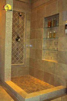 a walk in shower sitting next to a glass shelf with bottles on the shelves above it