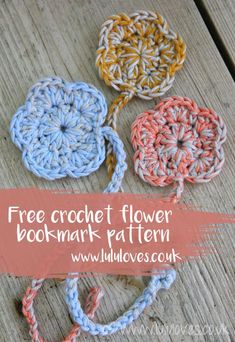 four crocheted flowers on a wooden surface