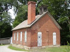 an old red brick building with a clock tower on the top and two white doors