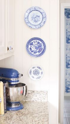 blue and white plates are hanging on the wall