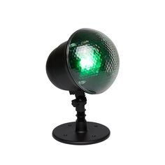 a green light on a black stand with a white back ground and no one around it