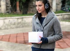 a woman wearing headphones holding a box