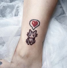 a small pixel heart tattoo on the ankle