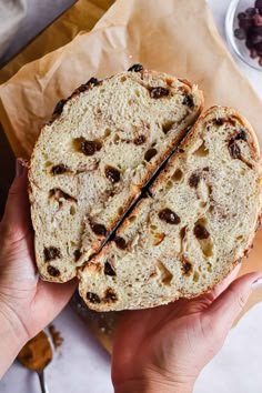 a person holding a piece of bread with raisins on it