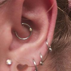 a close up of a person with ear piercings on their ears and behind the ear