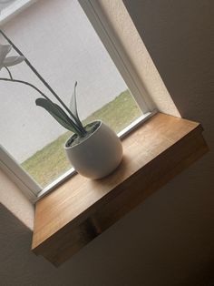 a white vase sitting on top of a window sill