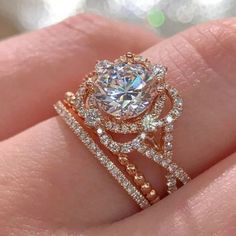 a woman's hand holding an engagement ring with two rows of diamonds on it